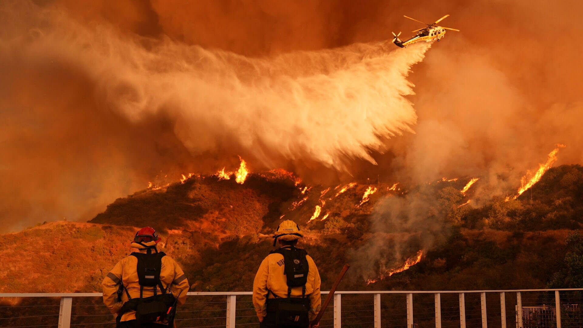 firefighters staring at fire as it is waterbombed