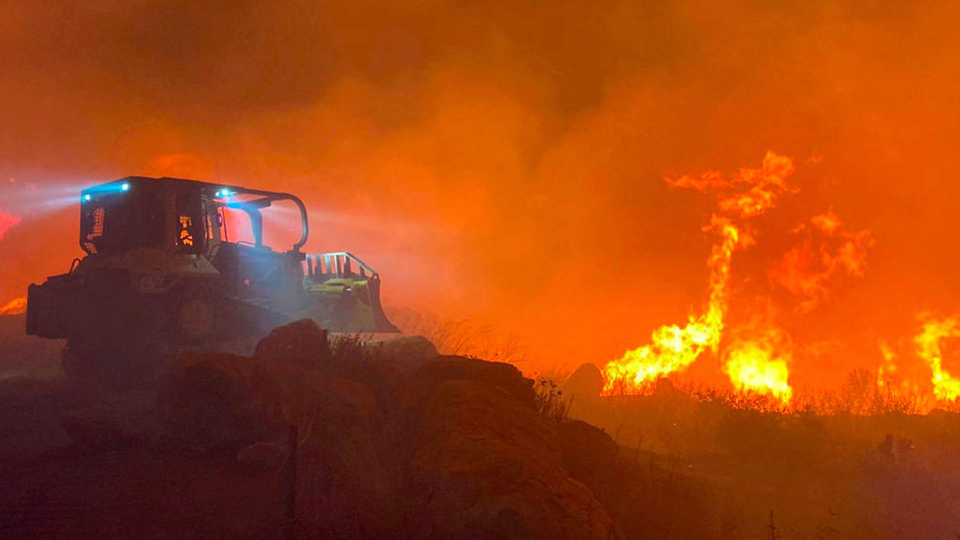 California Wildfire in the background behind vehicle
