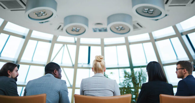 backs of employees in a large glass room