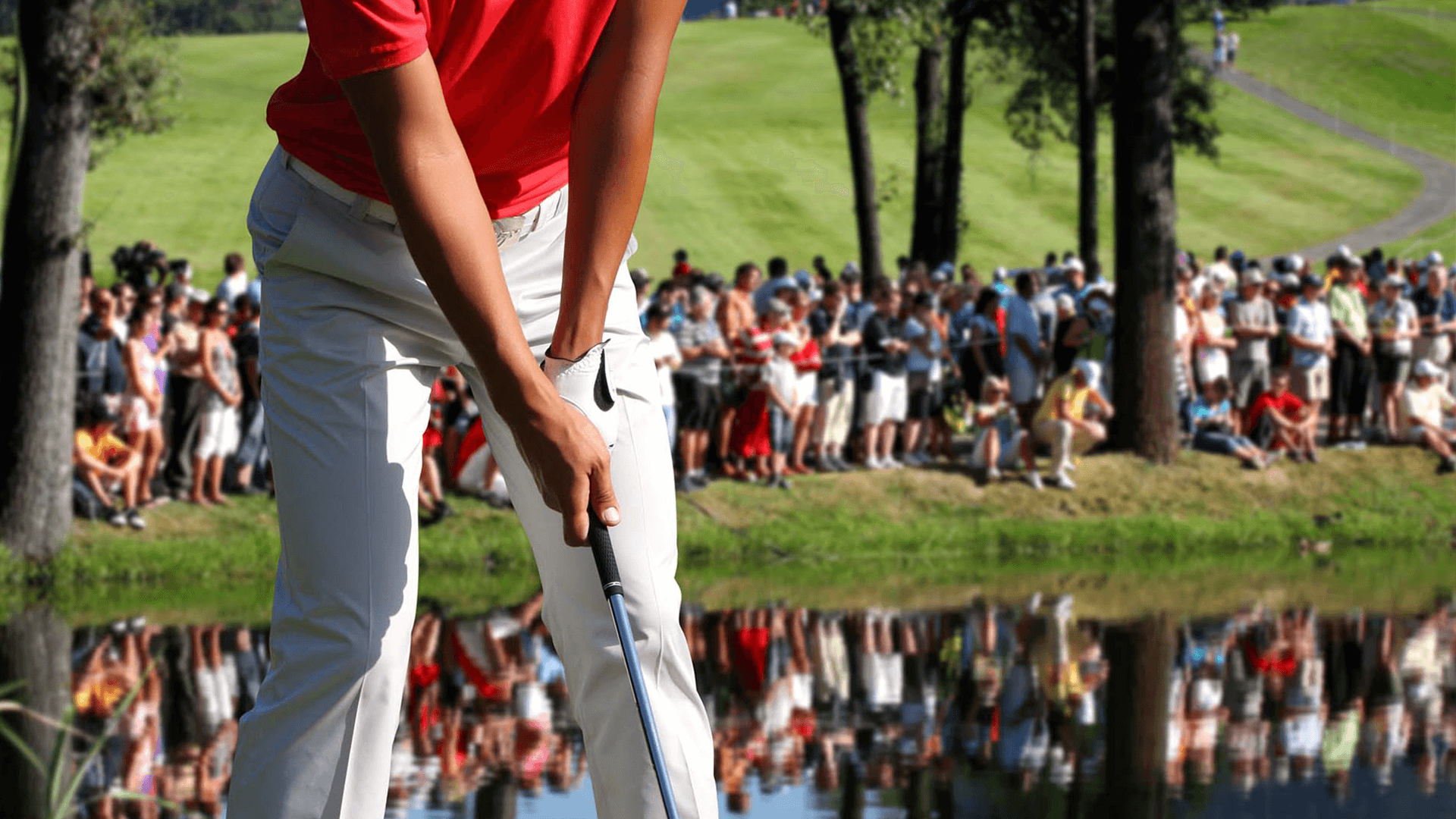 Male golfer swinging club at course