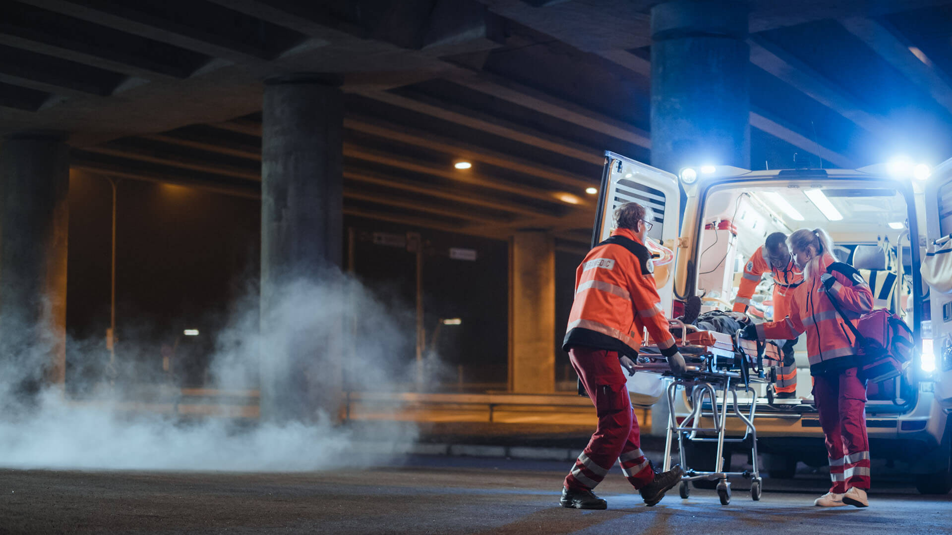 First responders loading a patient into a waiting ambulance