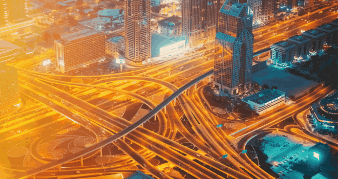 Aerial View Of Evening Night Traffic Of Dubai. City Street Night Yellow Illumination Of Residential District In Dubai. Night Scenic View Of Skyscraper In Dubai. Urban background. High quality photo.