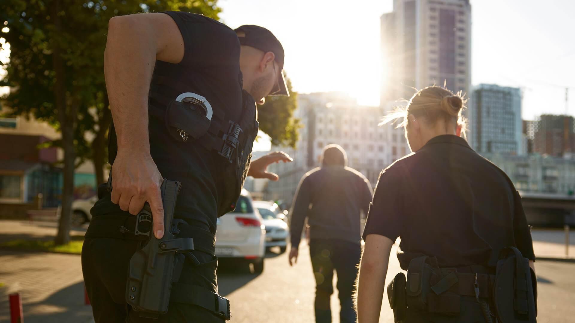 Police officers preparing weapons while approaching a suspect