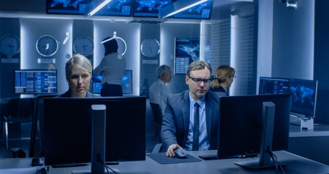 Agents working in a room surrounded by computer screens