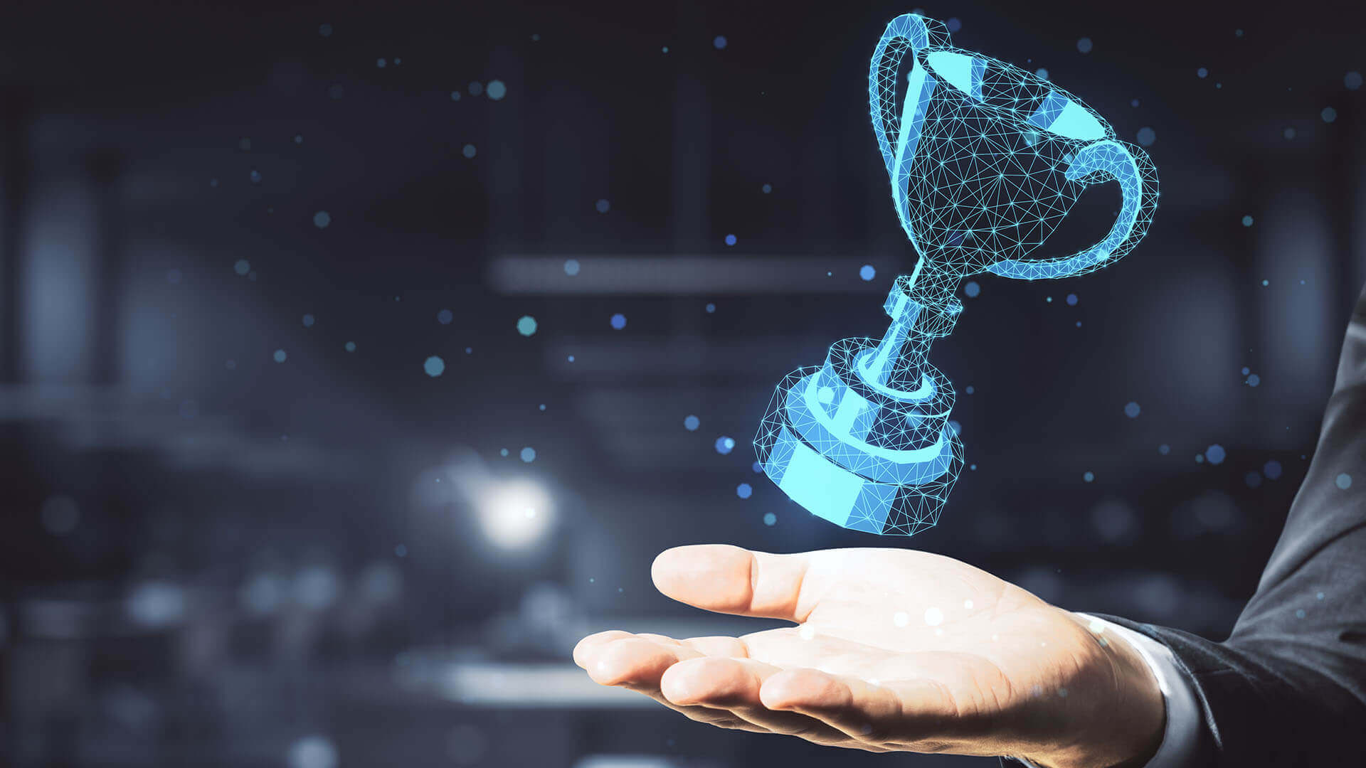 Hand Holding Glowing Polygonal Winner Cup On Office Background